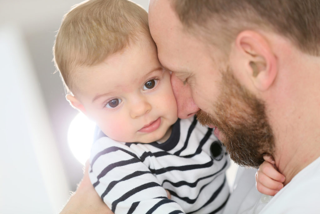 l'homme tient son enfant dans ses bras